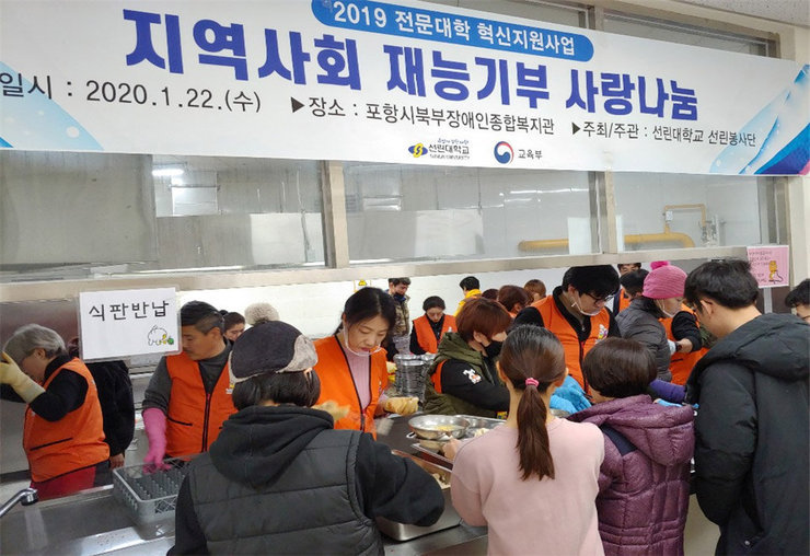 장애인종합복지관에서 음식을 식판에 담아주고 있는 사람들 모습
